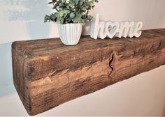 a potted plant sitting on top of a wooden shelf next to the word home