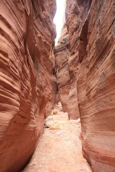 a narrow slot in the side of a mountain with rocks and dirt on both sides