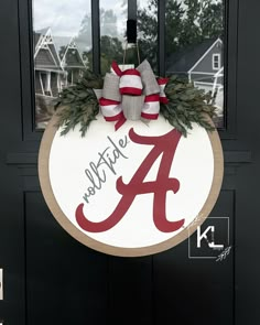 the front door is decorated with wreaths and bowes for an initial or letter