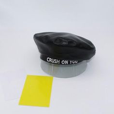 a black hat sitting on top of a table next to a yellow post it note