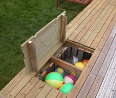 an outdoor play area made out of pallets and wooden boards with balls in it