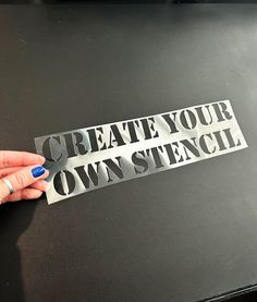 a person holding up a piece of paper that says create your own stencil