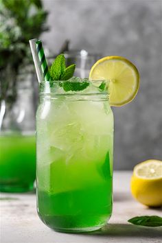 two glasses filled with green lemonade and mint