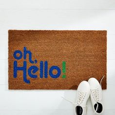 a door mat with the words oh hello written on it next to a pair of white shoes