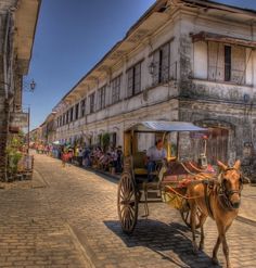 a horse drawn carriage traveling down a cobblestone street