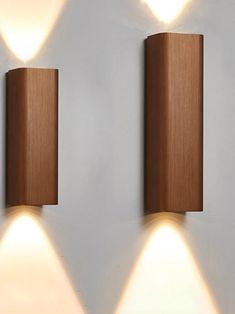 two wooden lights are on the wall next to each other