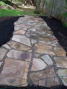 a stone path in the middle of a yard