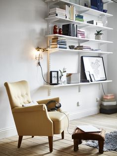 a chair and footstool in front of a bookshelf