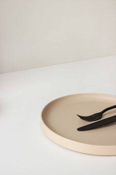 two black forks and spoons sitting on a white plate