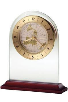 a clock that is sitting on top of a wooden base and has gold dials