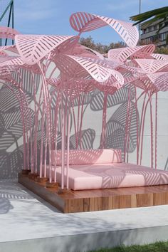 a pink bed sitting on top of a wooden platform