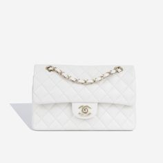 Sleek, refined and effortlessly chic, the Classic Small Flap Bag embodies Chanel’s non-traditionally feminine aesthetic. Crafted from white caviar leather and complimented by champagne-gold hardware, there is nothing more beautiful than this. SPL Exterior White caviar leather Champagne gold-tone hardware CC turn-lock closure Interwoven chain strap Rear slip pocket Plaque series - 2023 Brand new condition Interior Matching leather interior Spacious compartment Two slip pockets Brand new condition Comes with box, dustbag and receipt SPL Height 15cm Width 24cm Depth 7cm Iconic Handbags, History Of Fashion, Chanel Classic Flap Bag, Classic Flap Bag, Black Caviar, Feminine Aesthetic, Classic Flap, Champagne Gold, Leather Chain