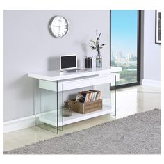 a white table with a laptop on top of it and a clock mounted to the wall