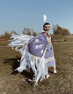 a native american woman dressed in purple and white