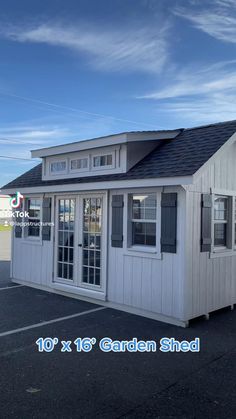 a small white building with black roof and windows