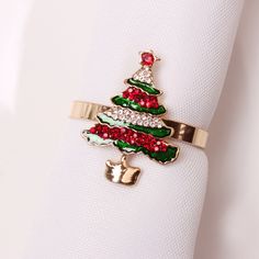 a napkin ring with a christmas tree on it and red, green, and white sequins