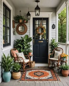 the front porch is decorated with potted plants and wicker chairs, along with an orange rug