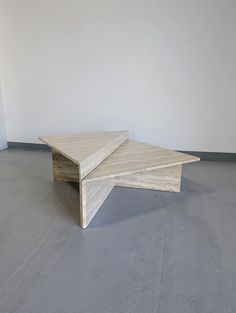 two tables sitting on top of each other in an empty room with concrete flooring