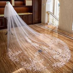 a wedding veil is on the floor in front of a chair with flowers all over it