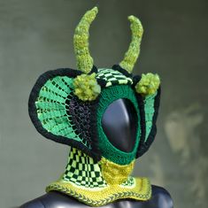 a crocheted hat with horns on top of a mannequin's head