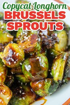 brussel sprouts with sesame seeds and brown sauce on a white plate