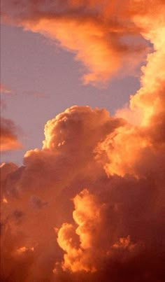 an airplane is flying in the sky with clouds behind it at sunset or sunrise time