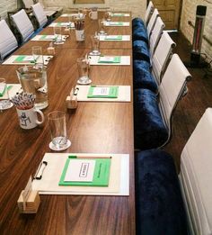 a long table is set up with place settings for people to sit down and eat