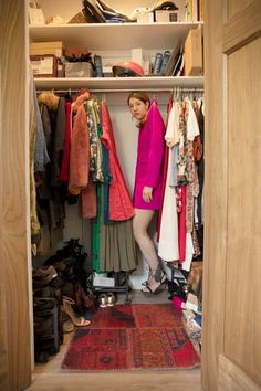 a woman standing in front of a closet full of clothes