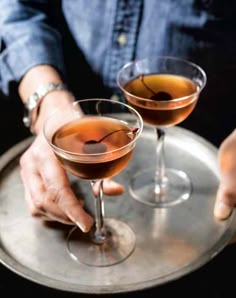 two martinis on a silver tray being served