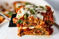 a close up of lasagna on a plate with a fork