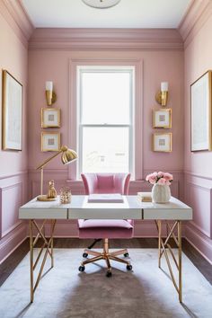 an office with pink walls and gold accents