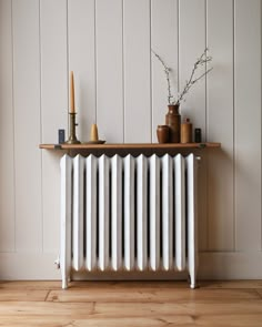 a white radiator sitting on top of a wooden floor next to a wall