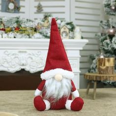 a red and white santa clause hat sitting on top of a bed next to a christmas tree