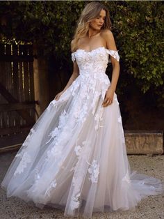 a woman in a white wedding dress posing for the camera with her hand on her hip