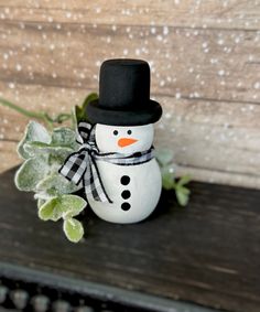 a small snowman sitting on top of a wooden table