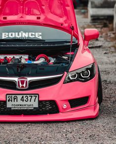 the hood of a pink honda car with an engine in it's trunk compartment