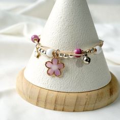 Handmade Japanese cherry blossom flower bracelet. Each bracelet with one acrylic cherry blossom charm and a small bell, the bracelet is adjustable in length (15cm to 19cm). Available in  Pink, Purple, Blue, Yellow Quantity: 1  Please note: Photography props and backdrops are not included. All items are handmade and therefore each item may have slightly differences. Want to find other Japanese style bracelets?  Please visit:  https://www.etsy.com/shop/cardstudiopro Cherry Blossom Wedding, Cherry Blossom Flowers, Japanese Cherry Blossom, Style Japonais, Flower Bracelet, Blossom Flower, Braided Bracelets, Photography Props, Fashion Bracelets