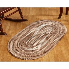 a brown and white rug sitting on top of a wooden floor next to a rocking chair