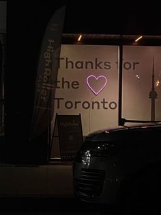 a car parked in front of a window with a pink heart on it's side