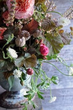 a vase filled with lots of flowers on top of a table