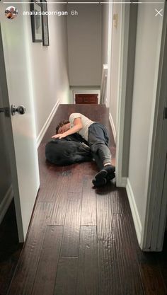 a man laying on the floor in an empty hallway