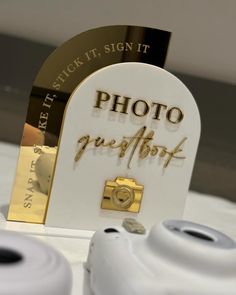 two white and gold cameras sitting next to each other on top of a table together