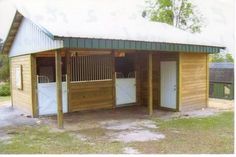 a horse barn with two stalls in the grass