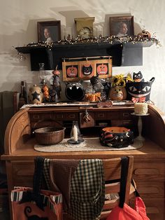 an old fashioned desk with halloween decorations on the top and bottom shelf, along with other items