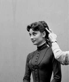 an old photo of a woman getting her hair combed by another woman's head