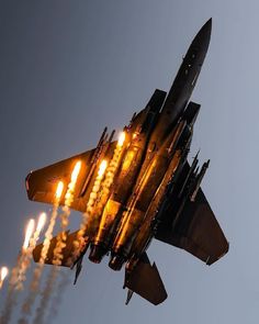 a fighter jet flying through the air with lots of lit candles