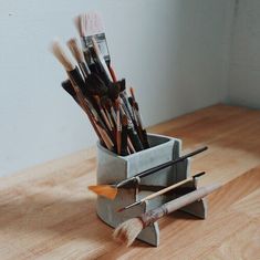 there are many brushes in the holder on the table