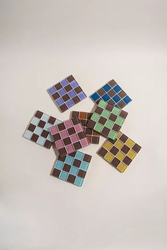 several pieces of colorful tile sitting on top of a white table next to each other