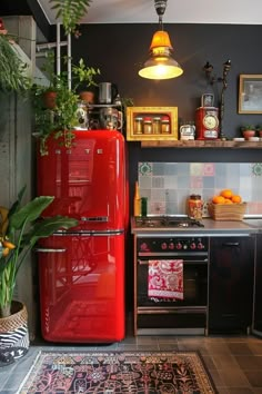 a red refrigerator freezer sitting inside of a kitchen next to a stove top oven