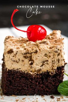 chocolate mousse cake on a white plate with a cherries garnish